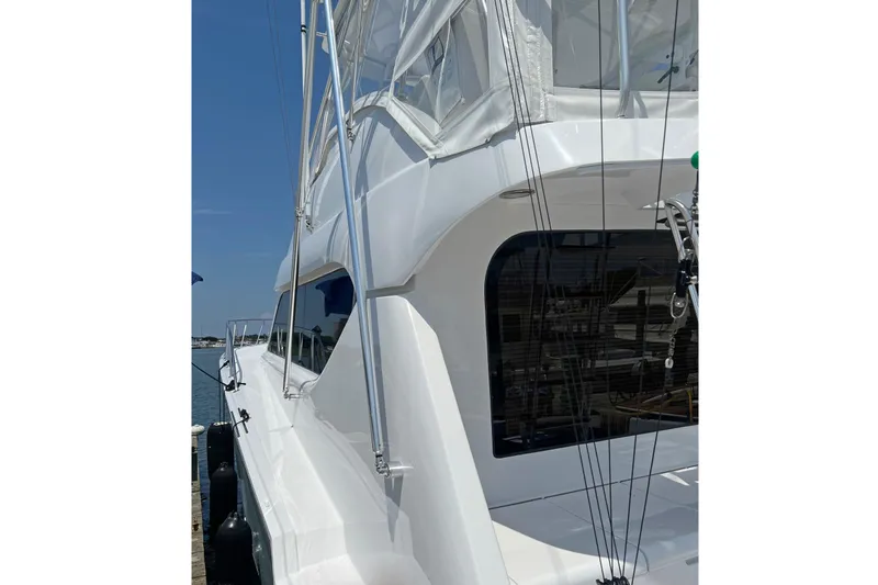 Slide: The Image of Hatteras 60 Convertible yacht, 2000 model, docked with visible rigging and sleek white exterior. - 2