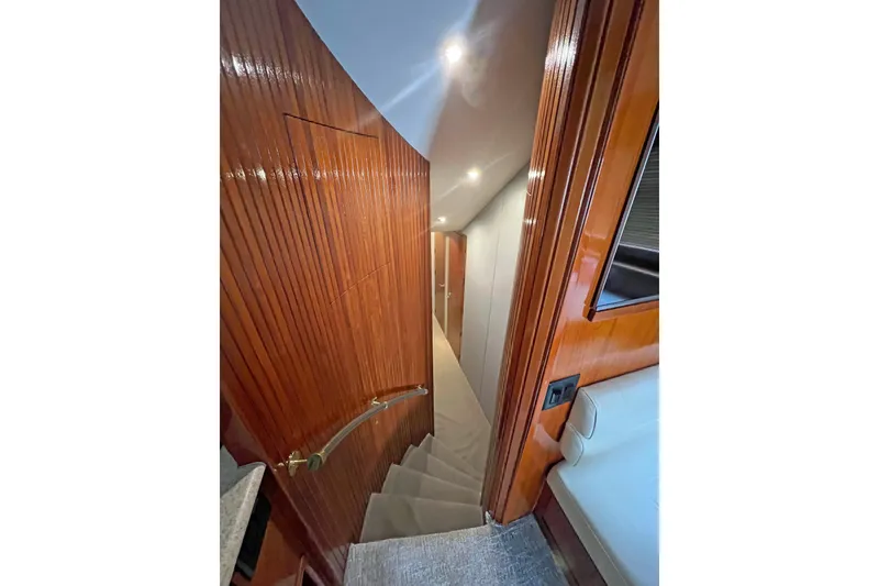 Slide: The Image of Interior staircase of 2000 Hatteras 60 Convertible yacht with polished wood finish. - 23