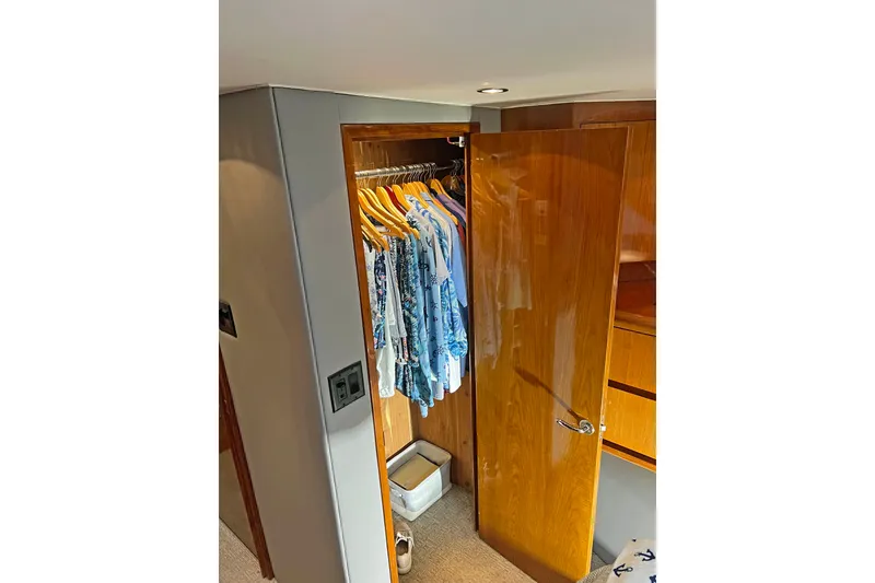 Slide: The Image of Wooden closet with clothes inside a 2000 Hatteras 60 Convertible yacht interior. - 30