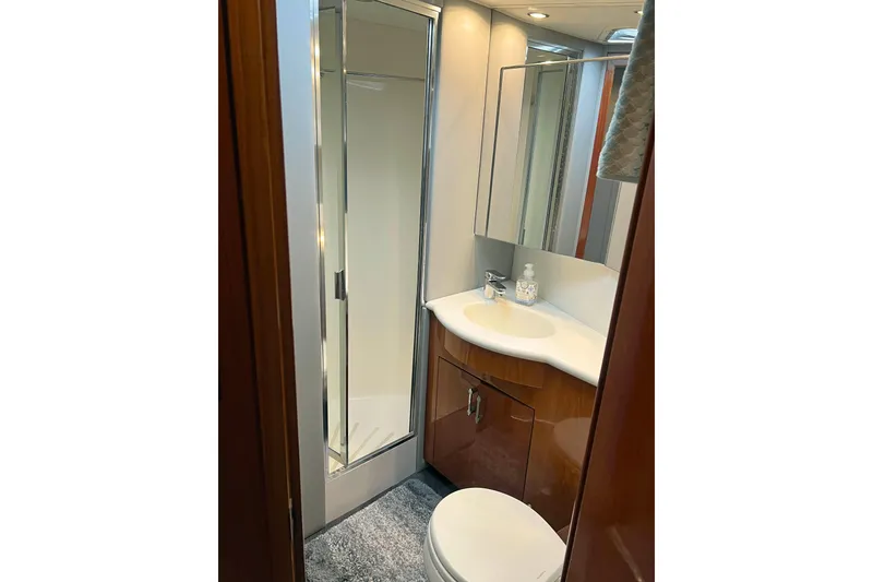 Slide: The Image of Bathroom interior of 2000 Hatteras 60 Convertible yacht, featuring shower, sink, and toilet. - 32