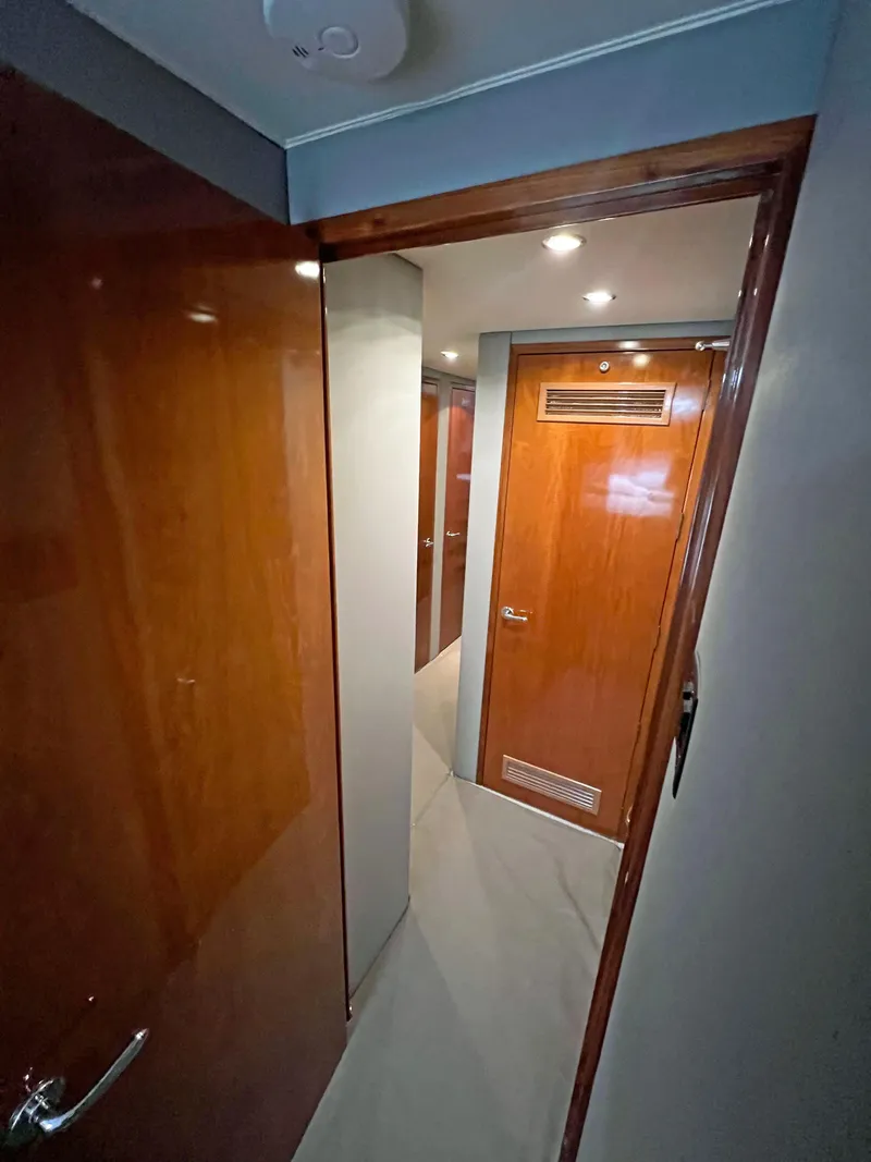 Slide: The Image of Interior hallway of 2000 Hatteras 60 Convertible yacht with wooden doors and modern lighting. - 33