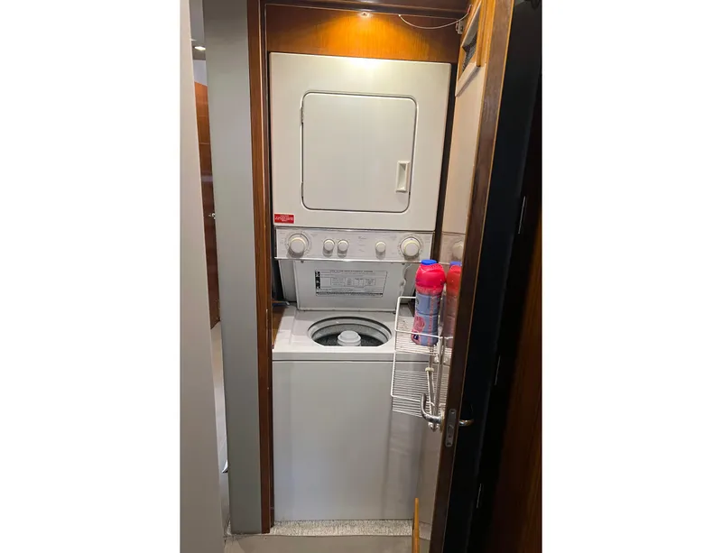 Slide: The Image of Laundry area with stacked washer and dryer on 2000 Hatteras 60 Convertible yacht. - 35