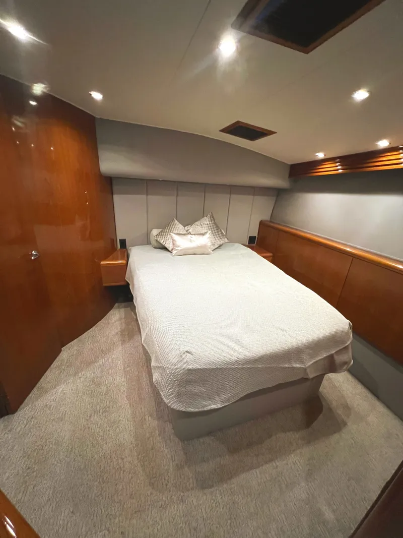 Slide: The Image of Luxurious bedroom interior of 2000 Hatteras 60 Convertible yacht with cozy bed and wood paneling. - 37