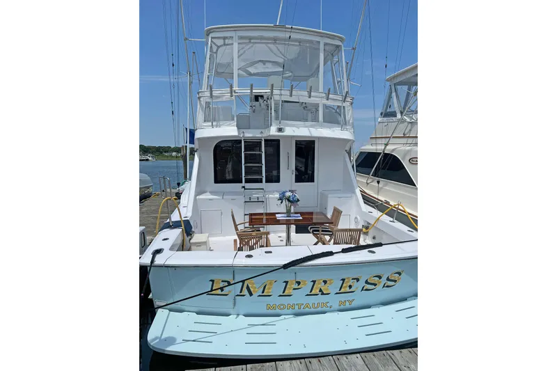 Slide: The Image of Hatteras 60 Convertible yacht, 2000 model, docked in Montauk, NY, with outdoor seating. - 4