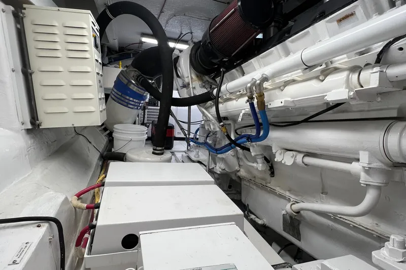 Slide: The Image of Engine room of 2000 Hatteras 60 Convertible yacht, showcasing mechanical components and piping. - 48