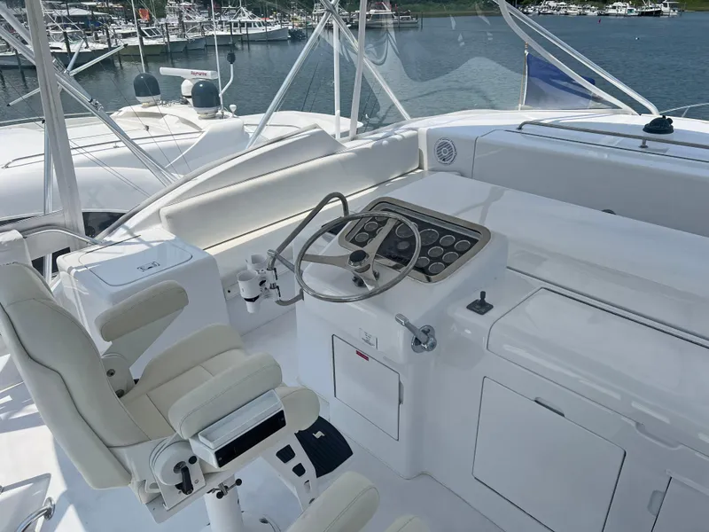 Slide: The Image of Helm of 2000 Hatteras 60 Convertible yacht with steering wheel and controls, docked at marina. - 9