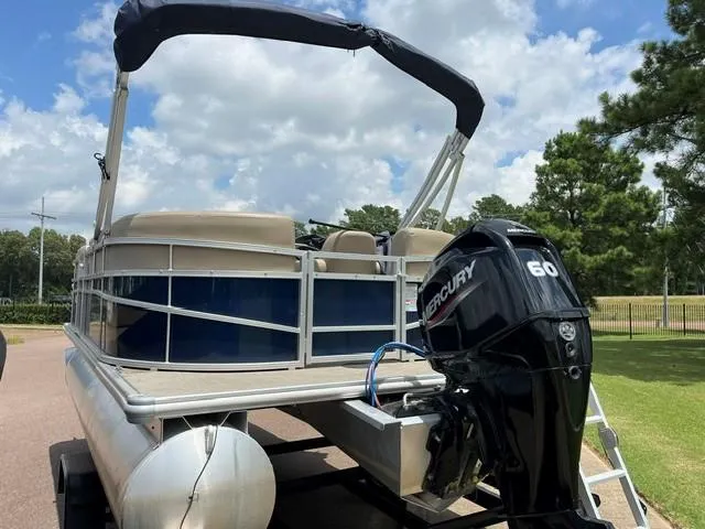 Slide: The Image of 2023 Starcraft LX18 R pontoon boat with Mercury 60 engine, parked outdoors. - 8
