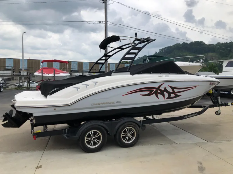 Slide: The Image of 2021 Chaparral 23 SSi boat on trailer, featuring sleek design and tribal graphics. - 1