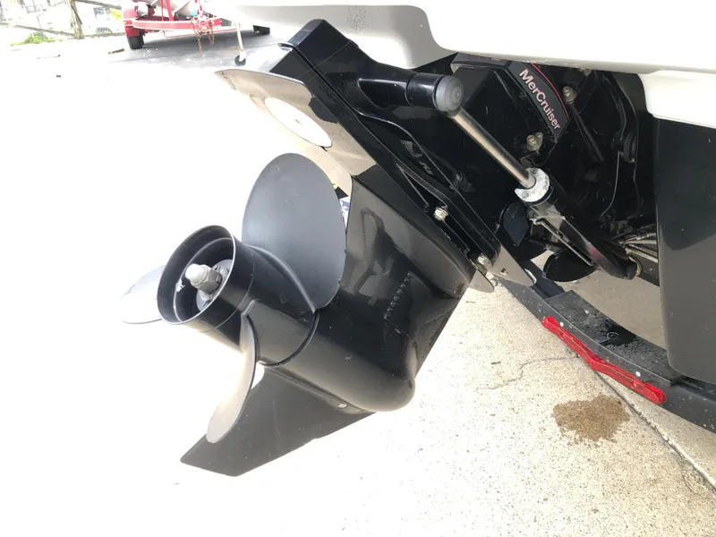 Slide: The Image of 2021 Chaparral 23 SSi boat with MerCruiser outdrive and propeller, parked on concrete. - 2