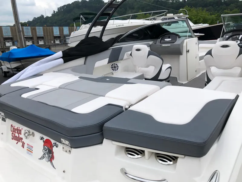 Slide: The Image of 2021 Chaparral 23 SSi boat with sleek seating and modern design at a marina. - 5