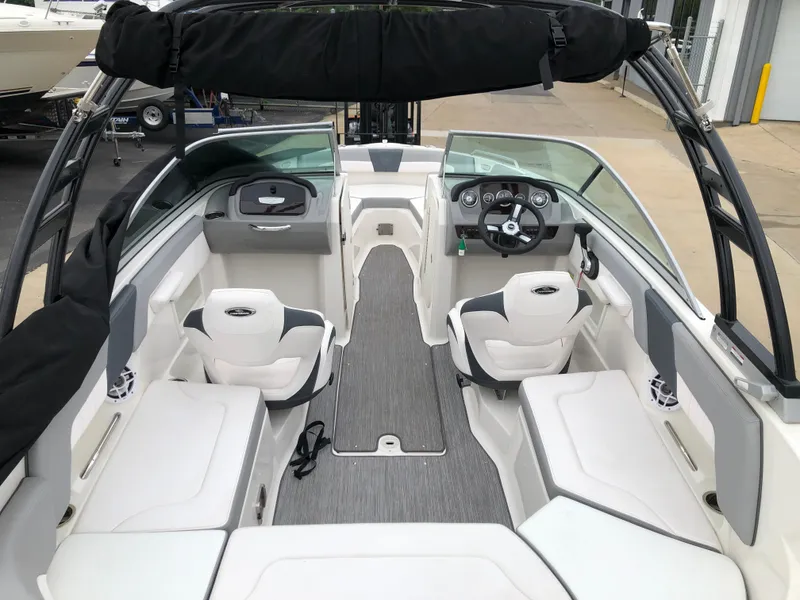 Slide: The Image of 2021 Chaparral 23 SSi boat interior with white seating and modern dashboard. - 6
