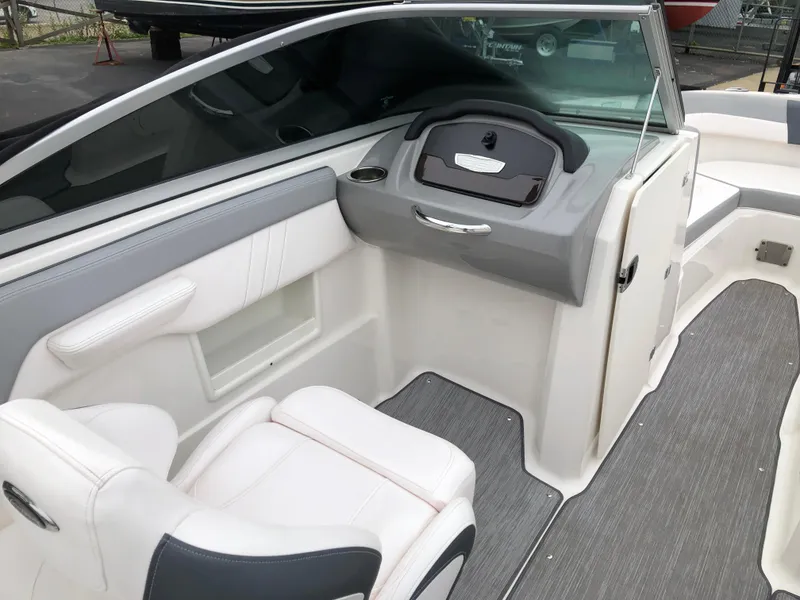 Slide: The Image of 2021 Chaparral 23 SSi boat interior with white seating and gray dashboard. - 7