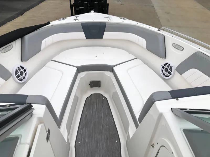 Slide: The Image of 2021 Chaparral 23 SSi boat interior with white and gray seating, speakers, and flooring. - 9