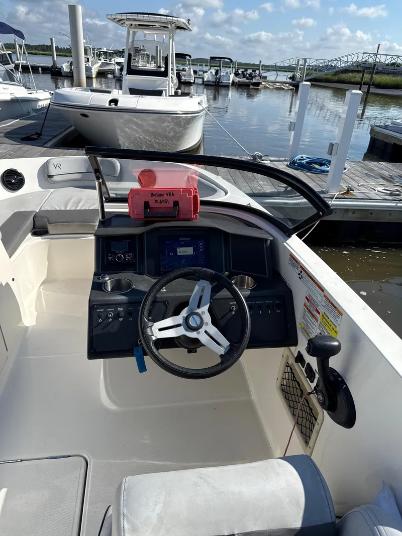 Slide: The Image of 2022 Bayliner VR6 Bowrider OB at marina, featuring steering console and docked boats. - 4