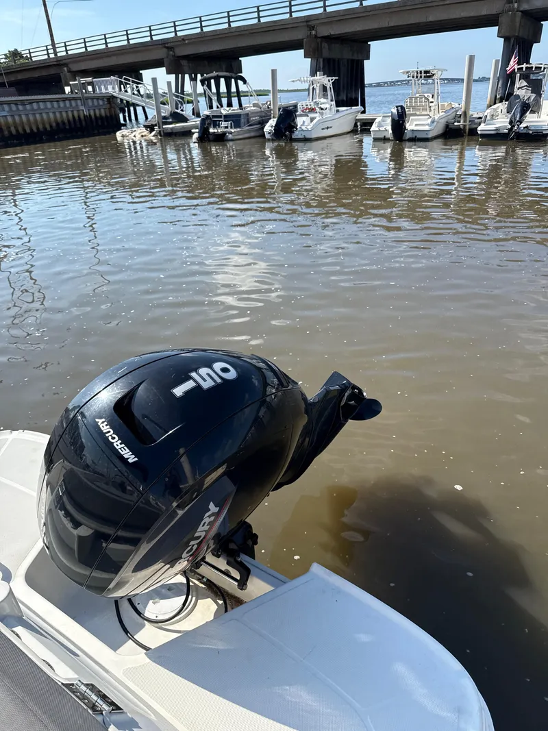 Slide: The Image of 2022 Bayliner VR6 Bowrider OB with Mercury outboard motor docked near a bridge. - 9