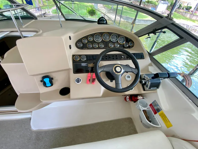 Slide: The Image of 1999 Cruisers Yachts 3375 Esprit helm with steering wheel and instrument panel, docked by water. - 16