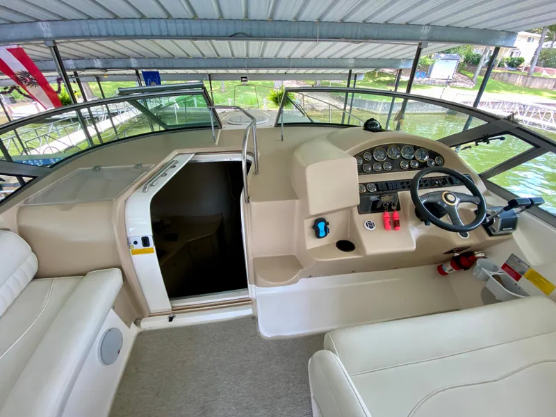 Slide: The Image of 1999 Cruisers Yachts 3375 Esprit helm with steering wheel, gauges, and seating under covered dock. - 17