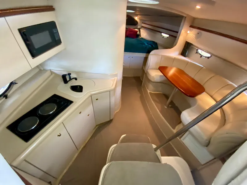 Slide: The Image of 1999 Cruisers Yachts 3375 Esprit interior with kitchen, seating area, and cozy sleeping quarters. - 19
