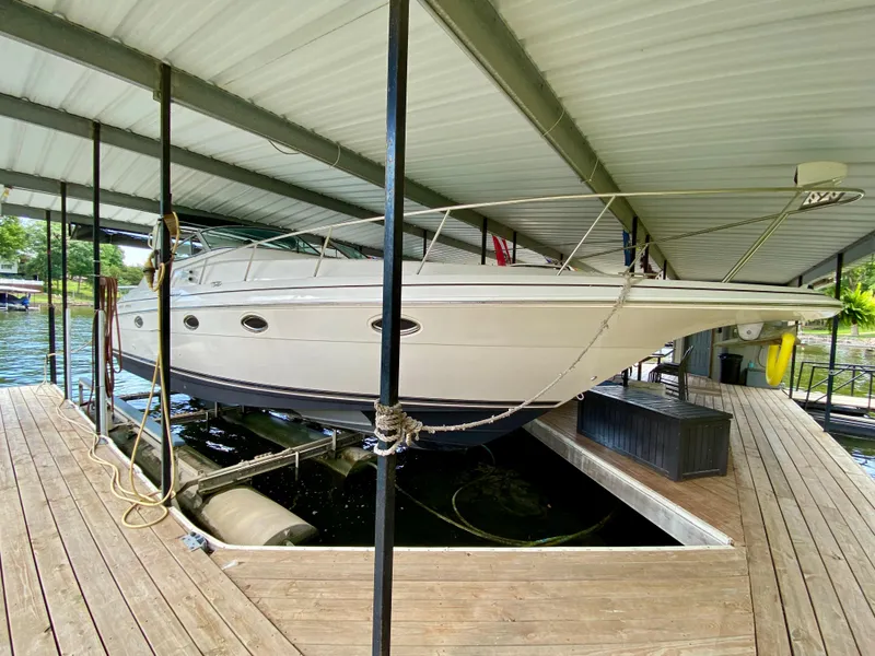 Slide: The Image of 1999 Cruisers Yachts 3375 Esprit docked in a covered marina. - 2