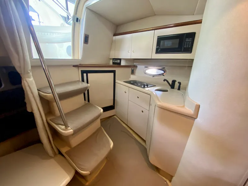 Slide: The Image of 1999 Cruisers Yachts 3375 Esprit interior kitchen with stairs, microwave, and sink. - 21