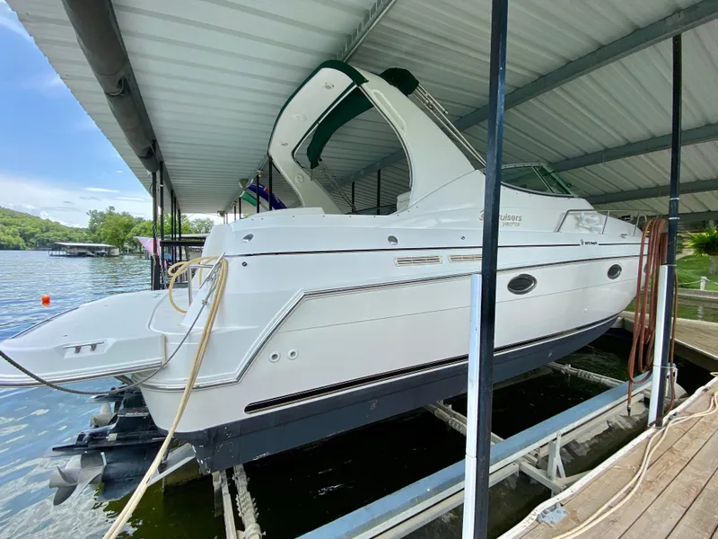 Slide: The Image of 1999 Cruisers Yachts 3375 Esprit docked under a covered marina. - 3