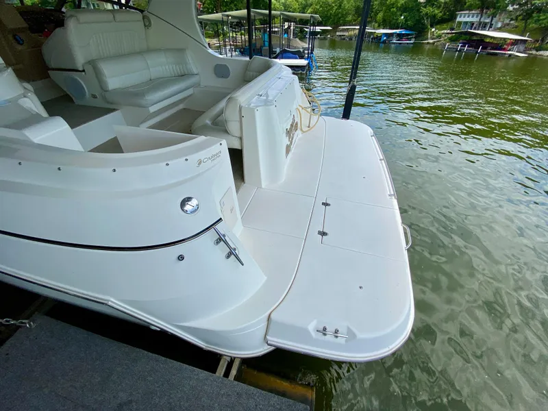 Slide: The Image of 1999 Cruisers Yachts 3375 Esprit docked, showcasing spacious deck and seating area. - 4