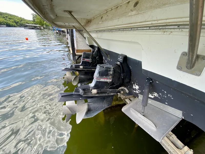 Slide: The Image of 1999 Cruisers Yachts 3375 Esprit with dual Mercury outdrives docked by the water. - 6