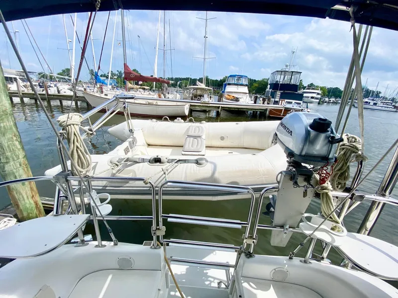 Slide: The Image of Sailboat docked at marina, featuring a 1995 Catalina 36 MkII with inflatable dinghy and outboard motor. - 19