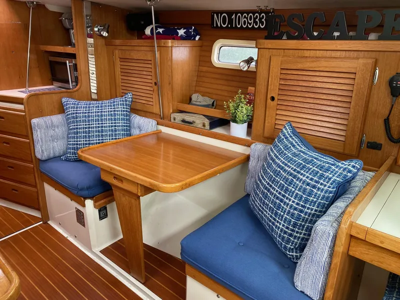 Slide: The Image of Interior of 1995 Catalina 36 MkII sailboat with wooden table, blue cushions, and decorative pillows. - 27