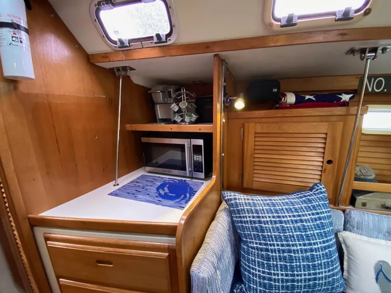 Slide: The Image of Interior of 1995 Catalina 36 MkII sailboat with microwave, wooden cabinets, and blue cushions. - 31