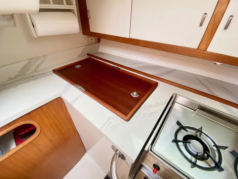 Slide: The Image of Catalina 36 MkII 1995 yacht kitchen with stove, countertop, and wooden cabinetry. - 36