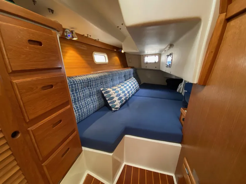 Slide: The Image of Interior of 1995 Catalina 36 MkII sailboat with cozy blue seating and wooden cabinetry. - 43