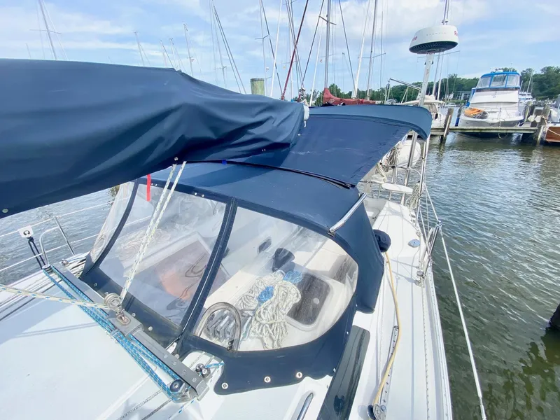 Slide: The Image of 1995 Catalina 36 MkII sailboat docked, featuring blue canvas covers and visible rigging. - 6