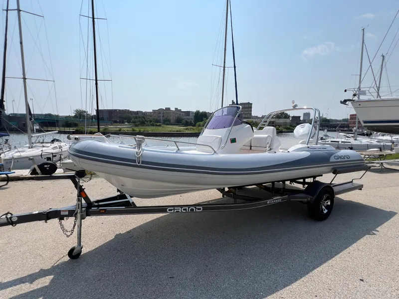 Slide: The Image of 2019 Grand G580HLF inflatable boat on trailer at marina, sunny day. - 1