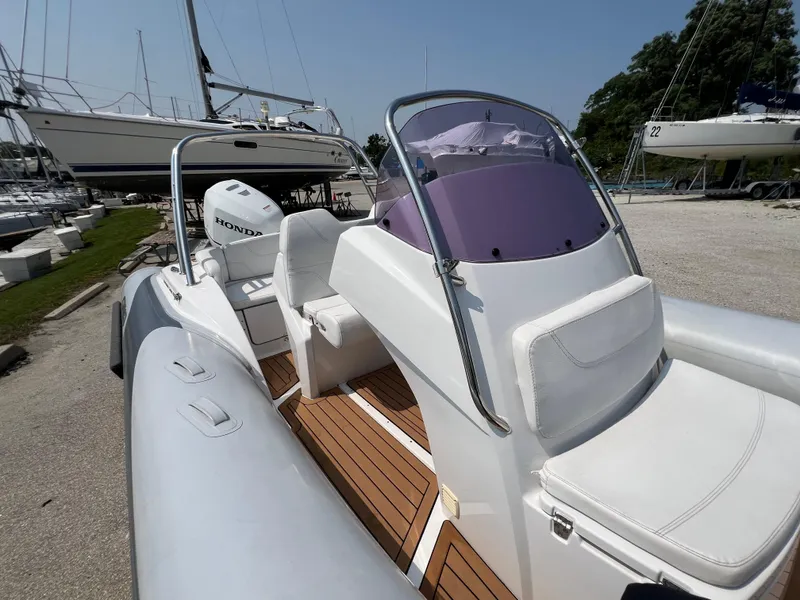 Slide: The Image of 2019 Grand G580HLF boat with Honda engine, docked near other sailboats. - 13