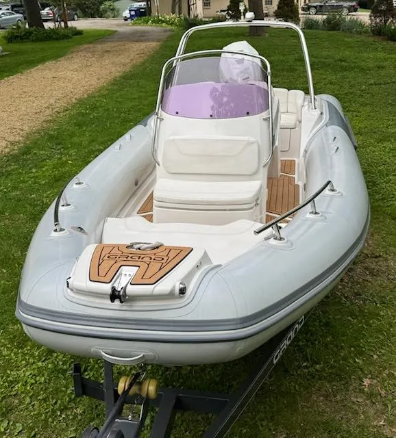 Slide: The Image of 2019 Grand G580HLF inflatable boat on trailer, parked on grass. - 19