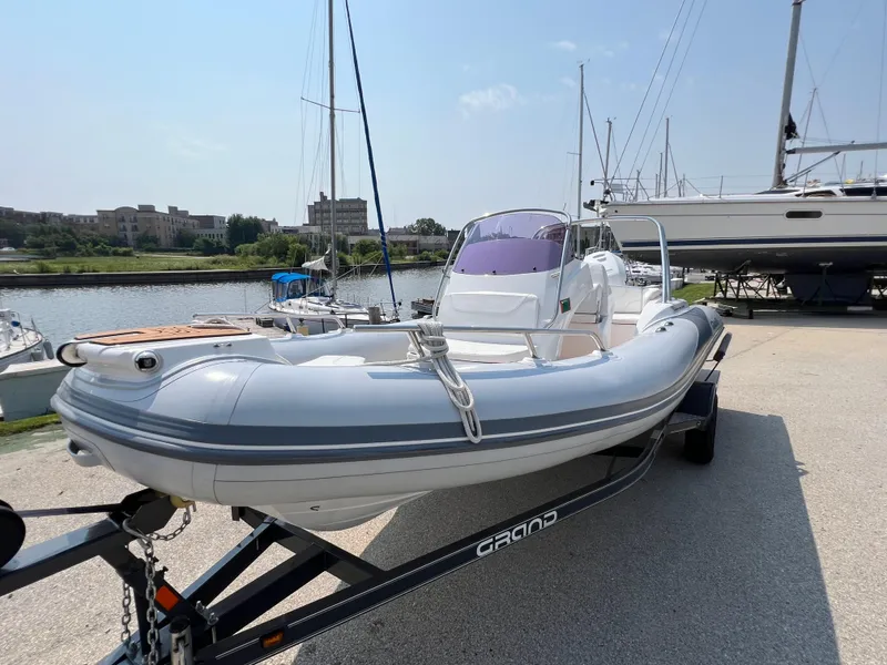 Slide: The Image of 2019 Grand G580HLF inflatable boat on trailer at marina. - 2