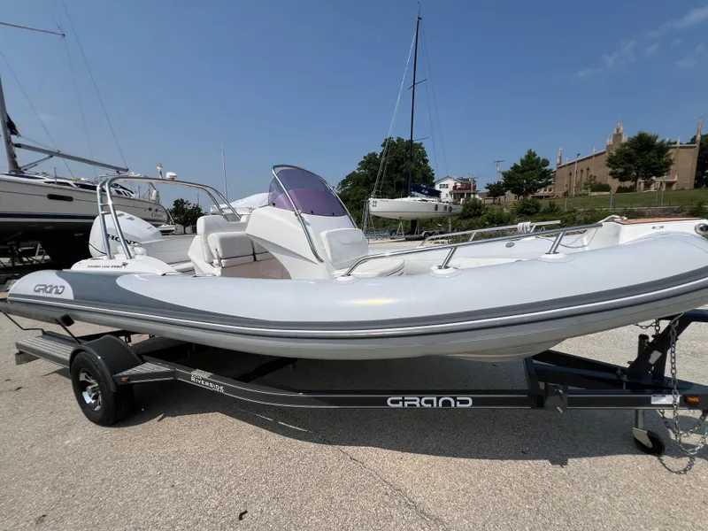 Slide: The Image of 2019 Grand G580HLF inflatable boat on trailer, parked outdoors under clear sky. - 4