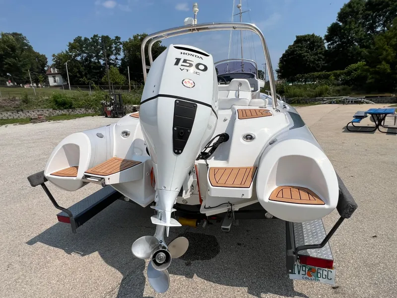 Slide: The Image of 2019 Grand G580HLF boat with Honda 150 engine on trailer, outdoor setting. - 6