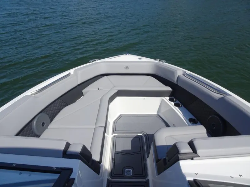 Slide: The Image of 2025 Cobalt R8 Surf boat interior with gray seating, on calm water. - 20