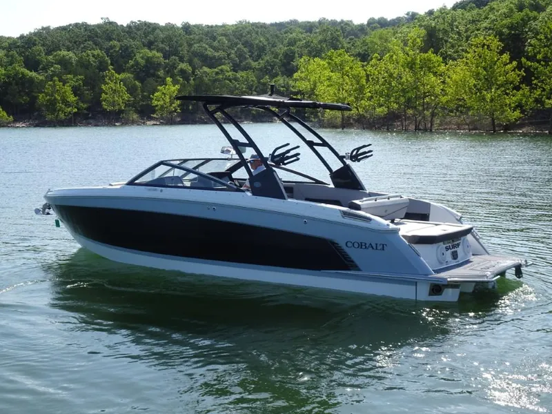 Slide: The Image of 2025 Cobalt R8 Surf boat on a serene lake with lush green trees. - 3