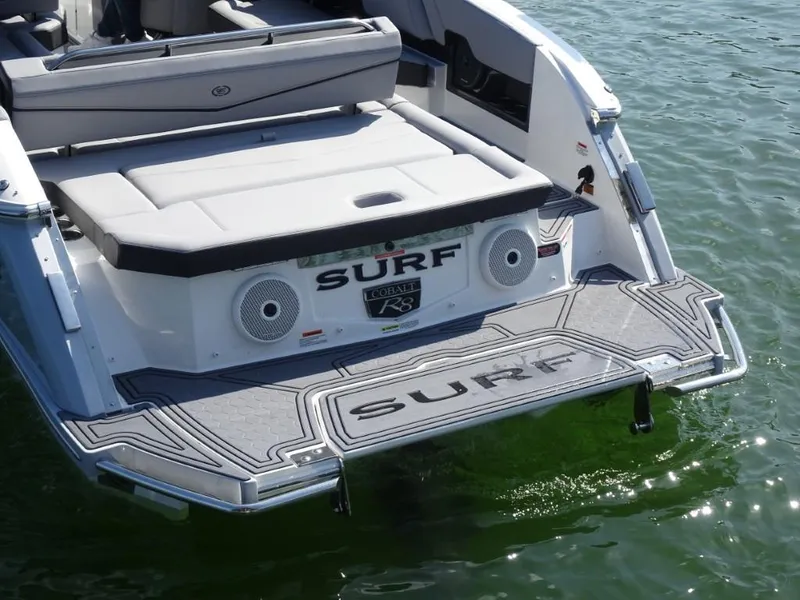 Slide: The Image of 2025 Cobalt R8 Surf boat rear view with swim platform on water. - 6