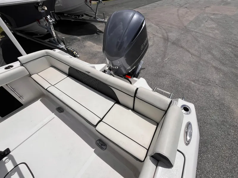 Slide: The Image of 2023 Tidewater 232 LXF boat with cushioned seating and Yamaha outboard motor. - 6