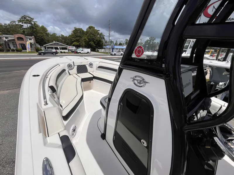 Slide: The Image of 2023 Tidewater 232 LXF boat interior with seating and console, parked outdoors. - 9