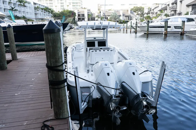 Slide: The Image of 2025 Caymas 291 HB boat docked in marina, featuring dual outboard engines. - 0