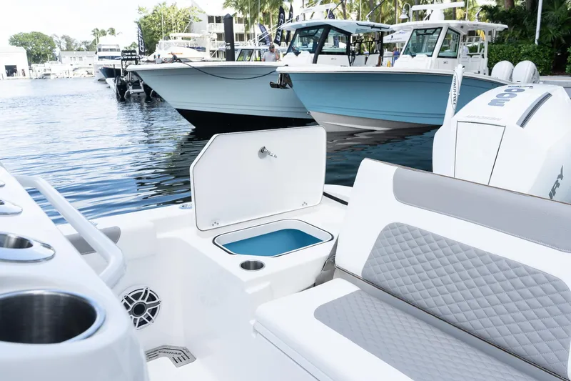 Slide: The Image of 2025 Caymas 291 HB boat interior with seating and storage, docked near other boats. - 10