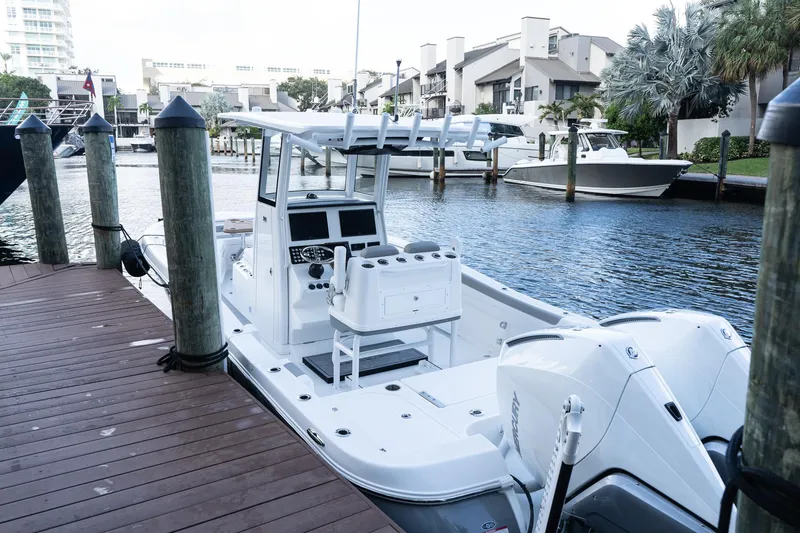 Slide: The Image of 2025 Caymas 291 HB boat docked in a marina, featuring dual outboard engines. - 2