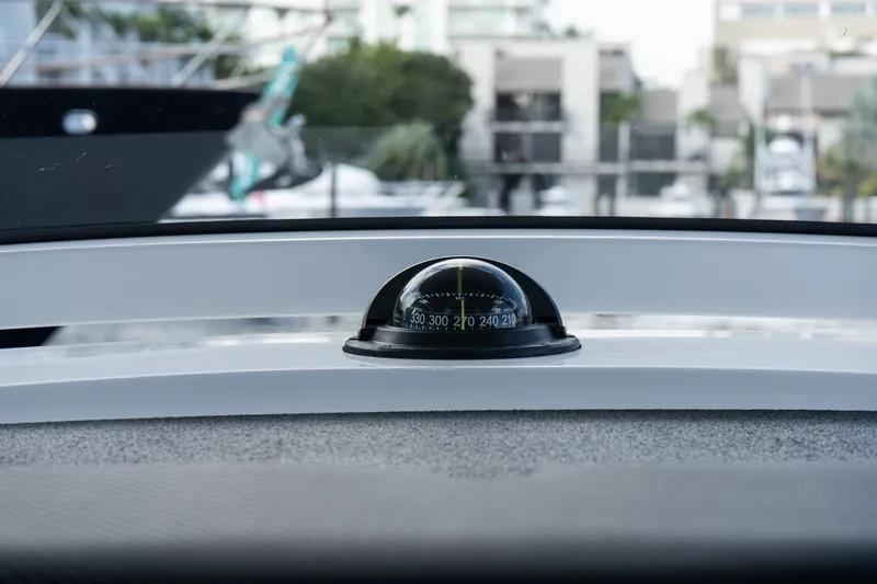 Slide: The Image of Compass on 2025 Caymas 291 HB boat dashboard, marina background. - 21