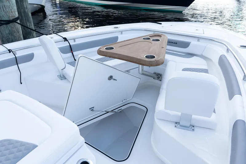 Slide: The Image of 2025 Caymas 291 HB boat interior with seating, storage, and table on the water. - 30
