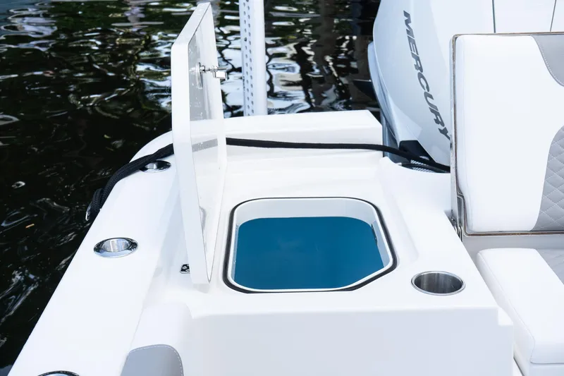 Slide: The Image of 2025 Caymas 291 HB boat with open storage compartment and seating, docked by water. - 8